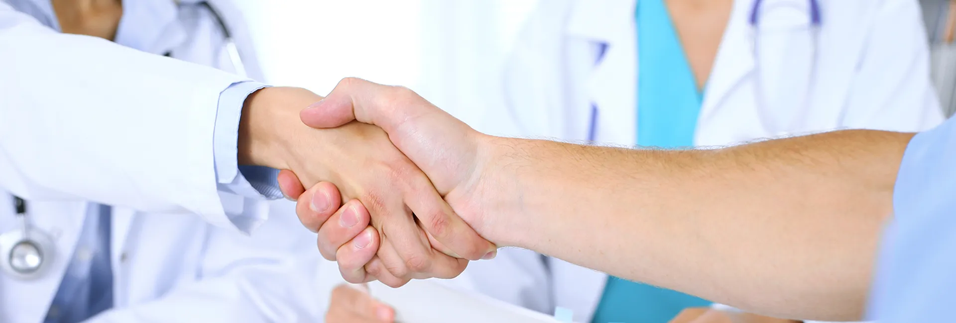 Stellenangebote RZ Saalfelden: Handschlag von Gesundheitspersonal